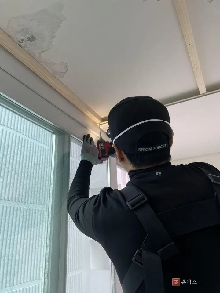 천장에 목재 골조를 대고 고정하는 작업 장면
