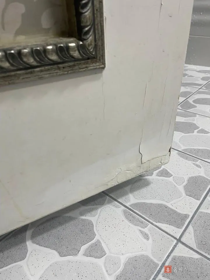 문짝 하단 모서리 페인트가 떨어져 나간 부분 근접 사진
