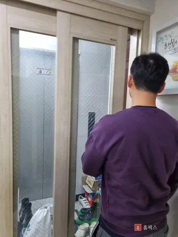 문짝을 다시 걸고 열고 닫으며 확인하는 모습