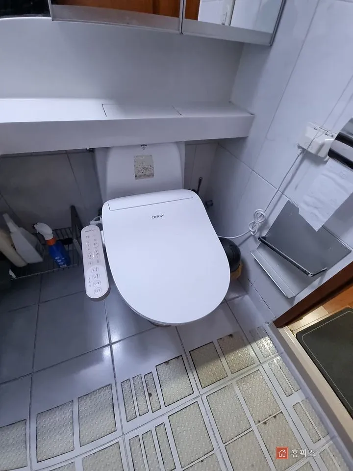 철거 전 욕실 변기와 상부 선반, 바닥 타일