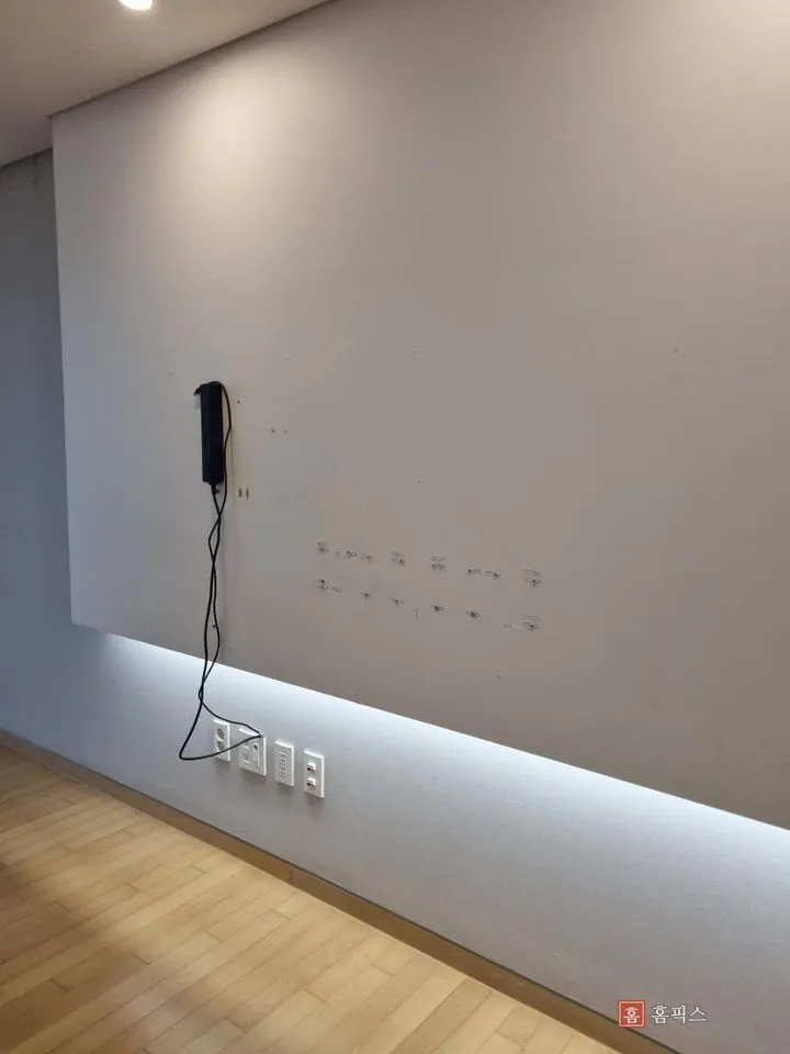 벽걸이 TV를 떼어낸 뒤 타공 흔적이 남은 거실 아트월 전경