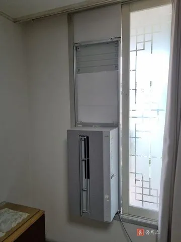 안방 창에 설치를 마친 창문형 에어컨과 위쪽 마감 부분