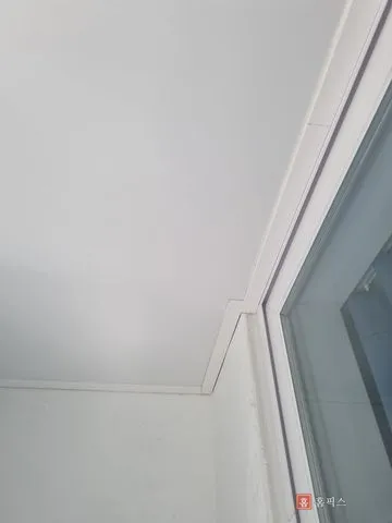 시공이 끝난 흰색 리빙보드 천장과 모서리 PVC 몰딩