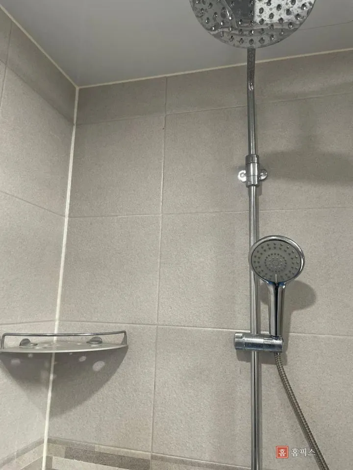 샤워기 거치대가 달린 욕실 벽타일 모서리 부분
